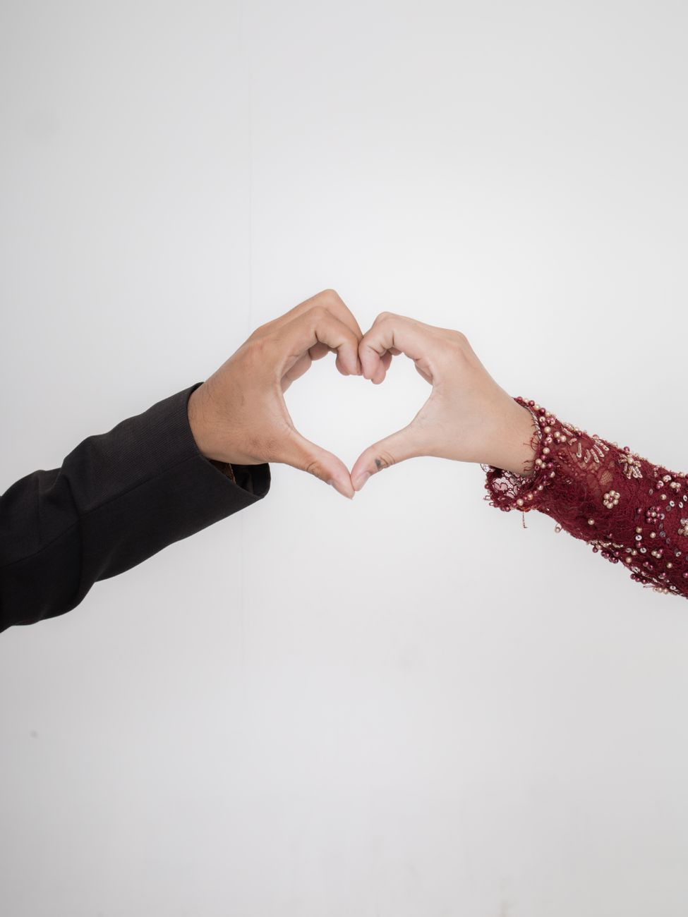 couple s hands forming heart shape on white bg